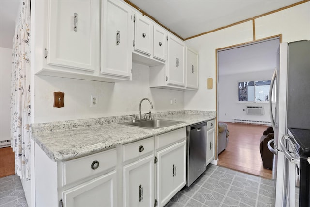 kitchen featuring appliances with stainless steel finishes, a baseboard heating unit, sink, light tile patterned floors, and white cabinets