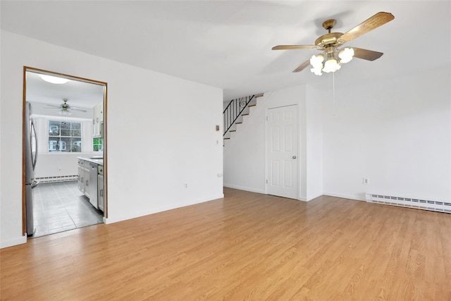 empty room featuring light hardwood / wood-style flooring, baseboard heating, and ceiling fan