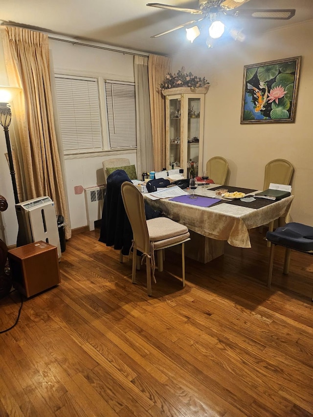 dining area featuring radiator heating unit, hardwood / wood-style flooring, and ceiling fan