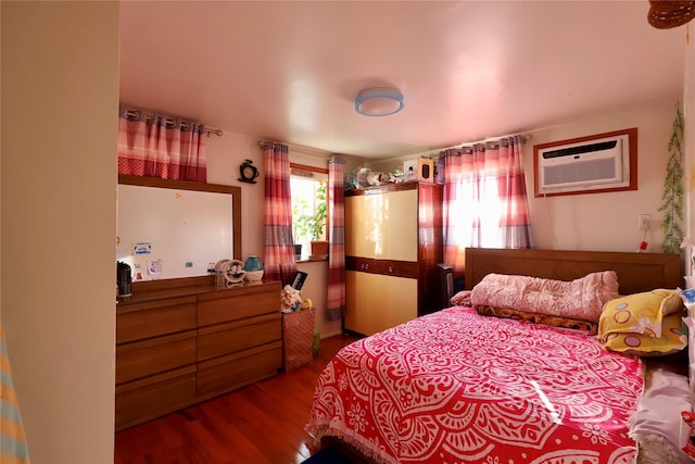 bedroom featuring a wall mounted air conditioner and hardwood / wood-style flooring