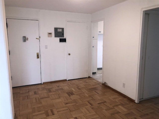 corridor with dark parquet floors and electric panel