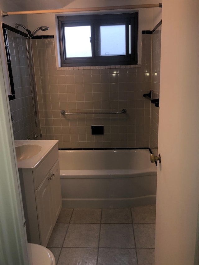 full bathroom featuring tile patterned flooring, vanity, tiled shower / bath combo, and toilet