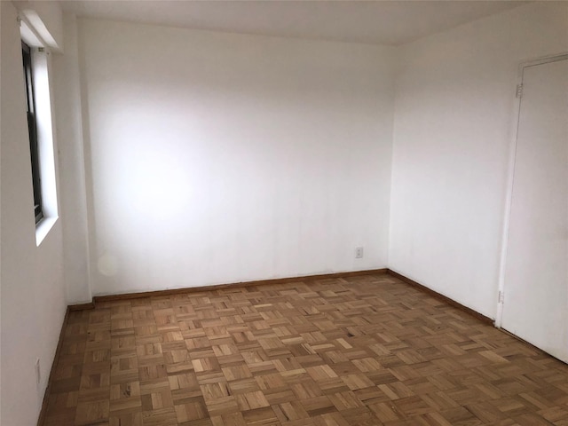 spare room with a healthy amount of sunlight and parquet flooring