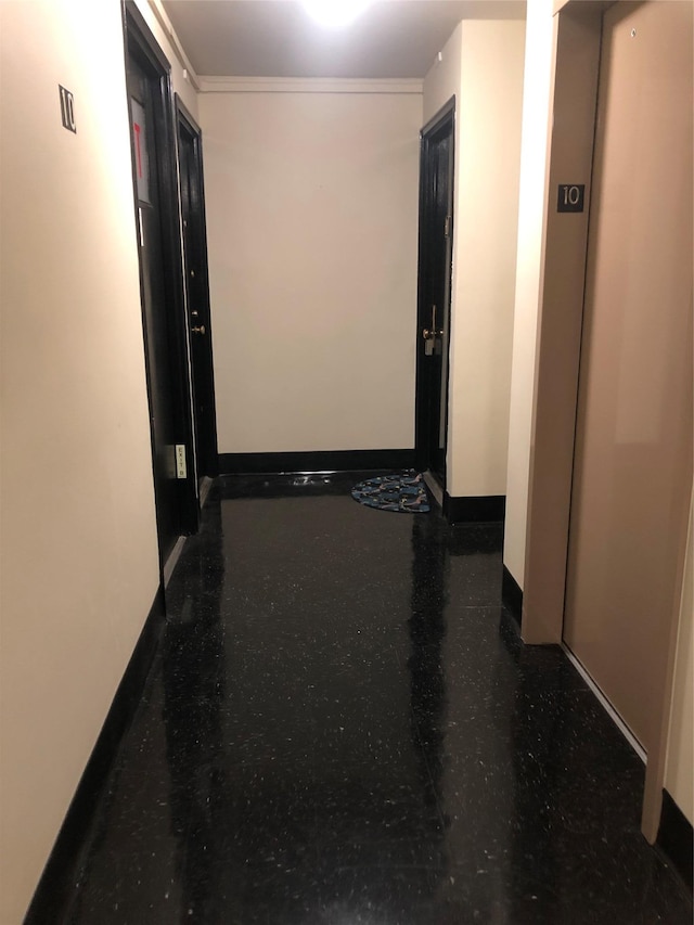 corridor with baseboards and ornamental molding