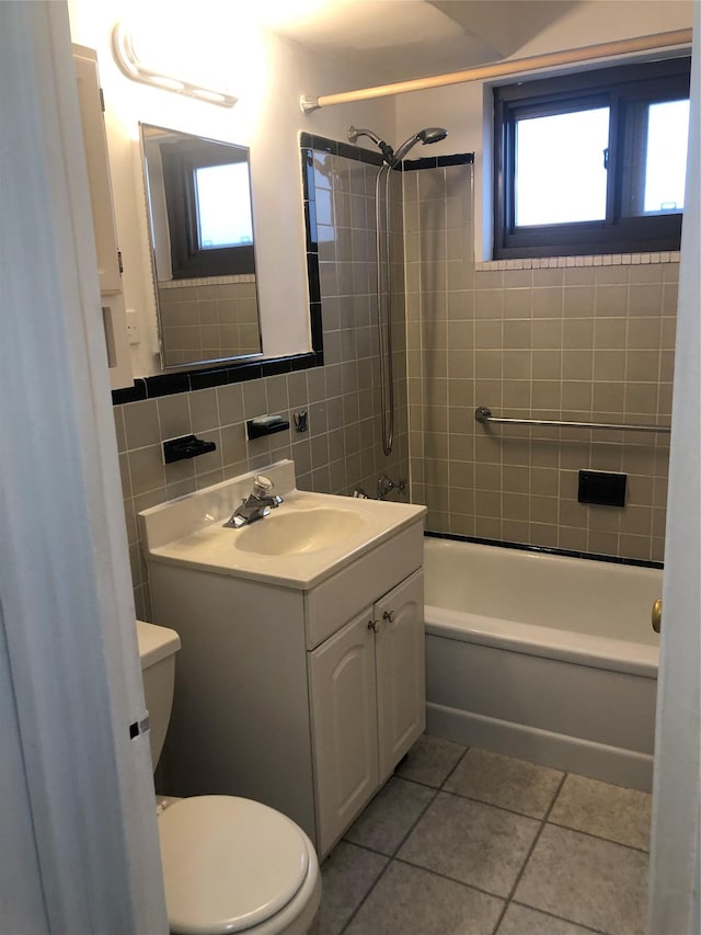 bathroom featuring tile patterned flooring, toilet, tile walls, and shower / bath combination