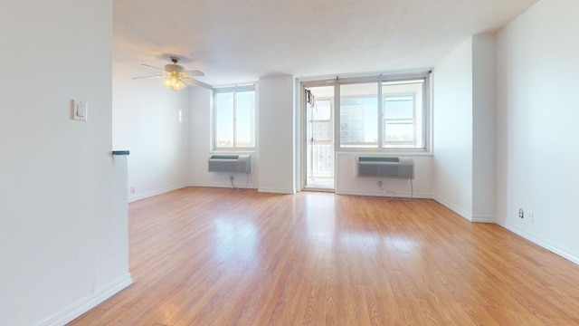 unfurnished living room with ceiling fan, light hardwood / wood-style flooring, and a wall mounted AC