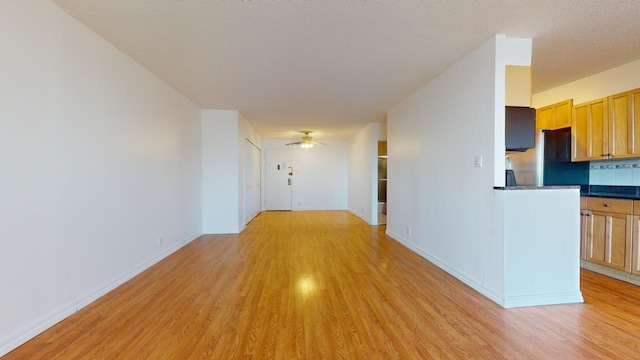 corridor featuring a textured ceiling and light wood-type flooring