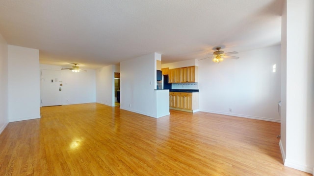 unfurnished living room featuring ceiling fan and light hardwood / wood-style floors