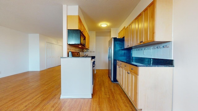 kitchen with decorative backsplash, light brown cabinetry, a textured ceiling, and light hardwood / wood-style flooring