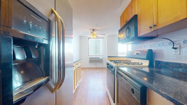 kitchen featuring ceiling fan, backsplash, fridge, light wood-type flooring, and gas range oven