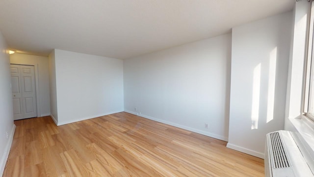 unfurnished room featuring a wall unit AC and light hardwood / wood-style floors