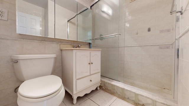 bathroom featuring toilet, tile patterned flooring, a shower with shower door, and vanity