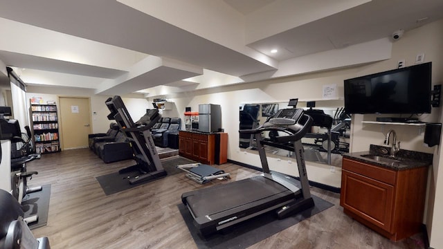 workout room with sink and light hardwood / wood-style floors