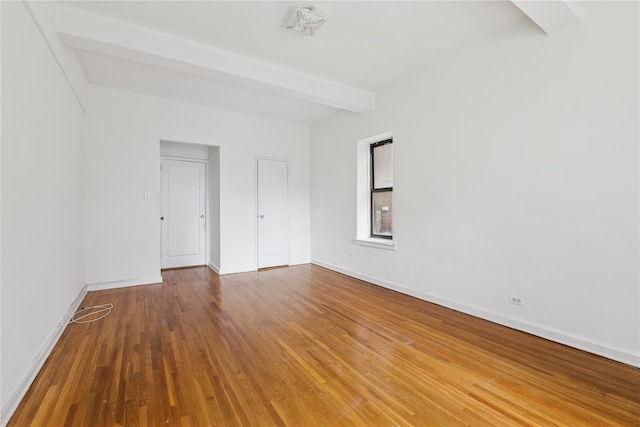 unfurnished room featuring beam ceiling and hardwood / wood-style floors