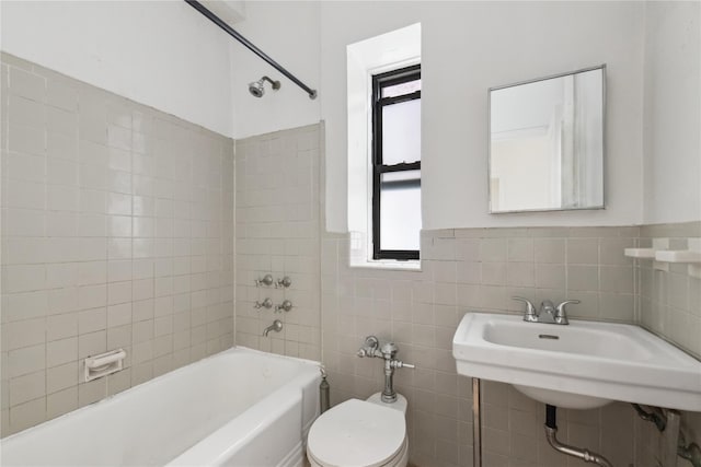 full bathroom featuring plenty of natural light, toilet, tile walls, and tiled shower / bath combo