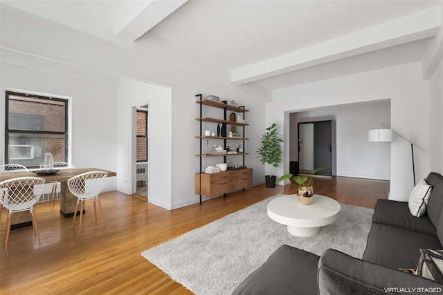 living room with wood-type flooring, radiator, and beam ceiling