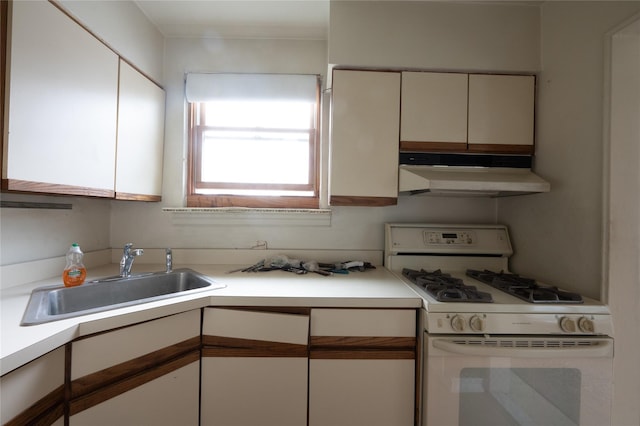 kitchen featuring white cabinetry, white gas range, and sink