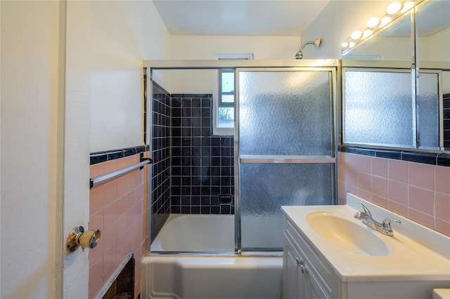 bathroom featuring backsplash, vanity, enclosed tub / shower combo, and tile walls