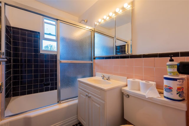 full bathroom with backsplash, toilet, shower / bath combination with glass door, vanity, and tile walls