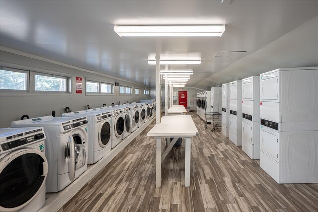 clothes washing area featuring washer and clothes dryer, hardwood / wood-style flooring, and stacked washer / dryer