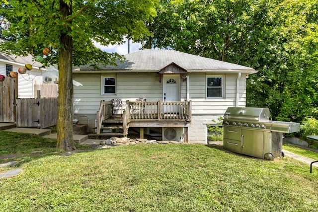 view of front facade with a wooden deck and a front lawn