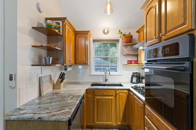 kitchen featuring backsplash, light stone countertops, sink, and black appliances