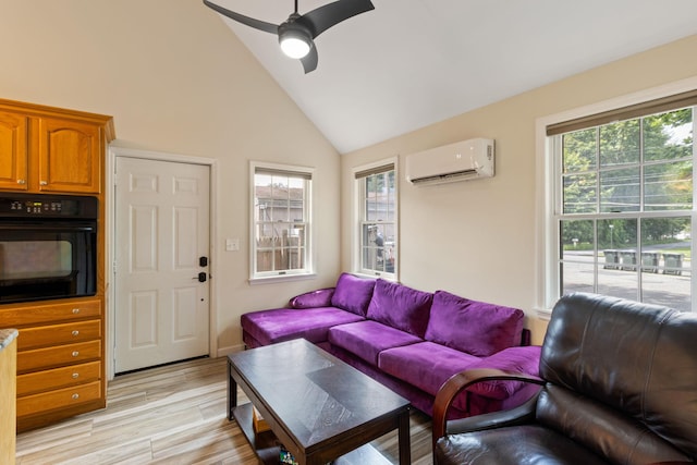 living room featuring ceiling fan, a healthy amount of sunlight, light wood-type flooring, and a wall unit AC