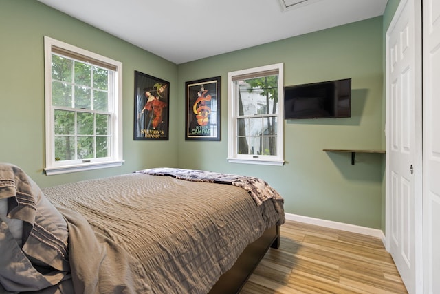 bedroom with light hardwood / wood-style floors and a closet