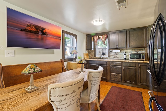 kitchen featuring backsplash, dark brown cabinets, stainless steel appliances, and sink