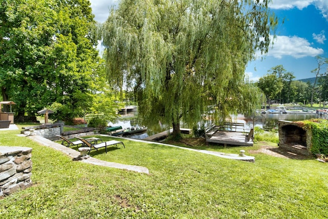 view of home's community featuring a water view, a yard, and a dock