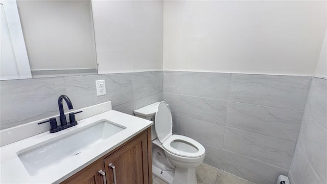 bathroom with vanity, tile walls, and toilet