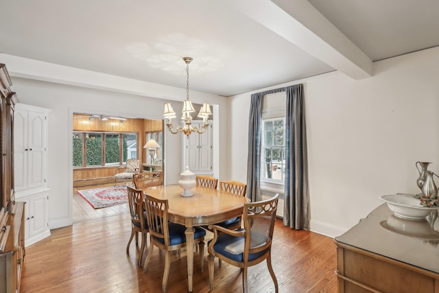 dining area with baseboard heating, beam ceiling, a notable chandelier, and light wood-type flooring