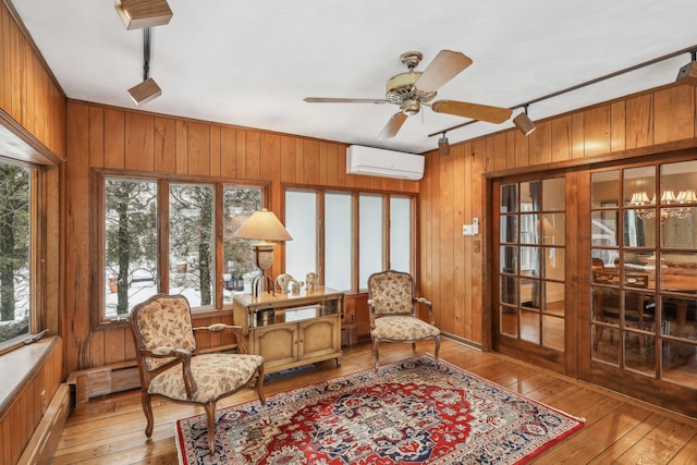 sunroom / solarium with rail lighting, a baseboard radiator, an AC wall unit, and ceiling fan