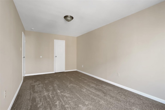 unfurnished room featuring dark carpet