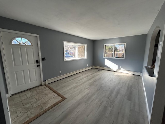 entryway with light wood-type flooring and a baseboard heating unit