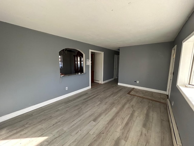 unfurnished room with light hardwood / wood-style floors and a baseboard radiator