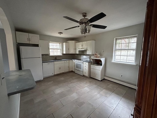 kitchen with white appliances, white cabinetry, a baseboard heating unit, sink, and ceiling fan