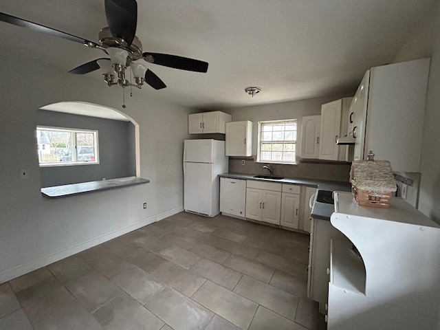 kitchen with ceiling fan, decorative backsplash, white appliances, white cabinets, and sink