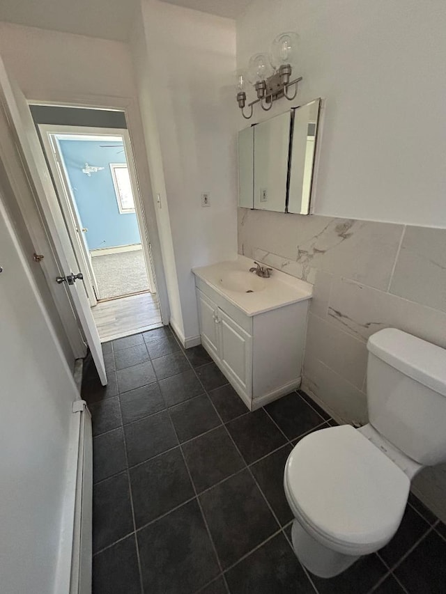 bathroom with toilet, tile walls, and vanity