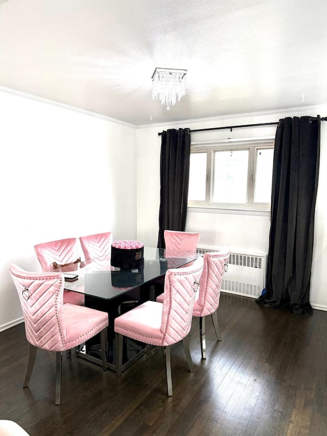 dining room with dark hardwood / wood-style flooring, radiator, ornamental molding, and an inviting chandelier