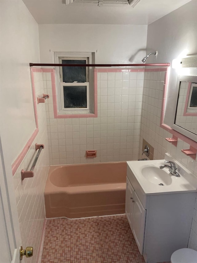 bathroom with tile patterned floors, vanity, tile walls, and bathtub / shower combination