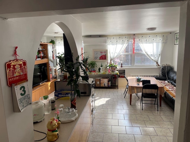 dining space featuring light tile patterned flooring and radiator