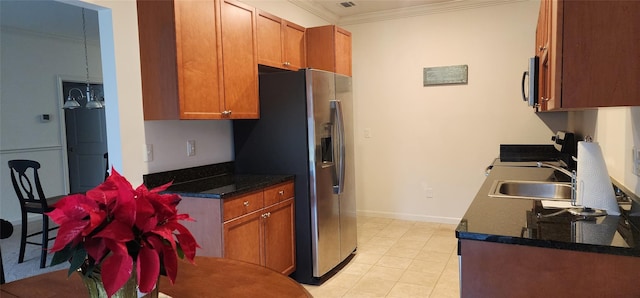 kitchen with sink, light tile patterned flooring, ornamental molding, and appliances with stainless steel finishes