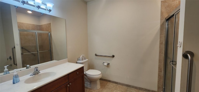 bathroom featuring tile patterned floors, vanity, a shower with shower door, and toilet