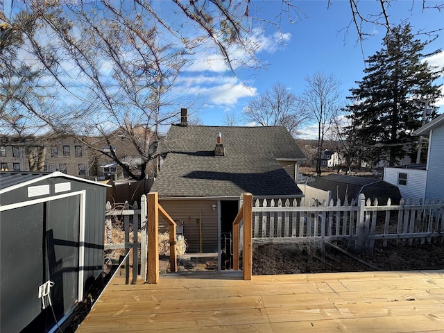 back of house featuring a storage shed and a deck