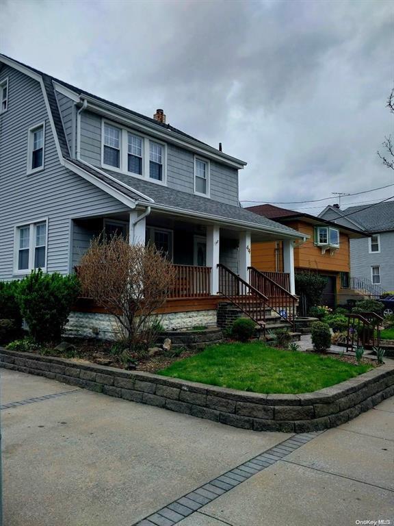 view of front of house with covered porch and a wall mounted air conditioner