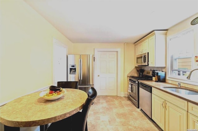 kitchen with cream cabinetry, appliances with stainless steel finishes, and sink