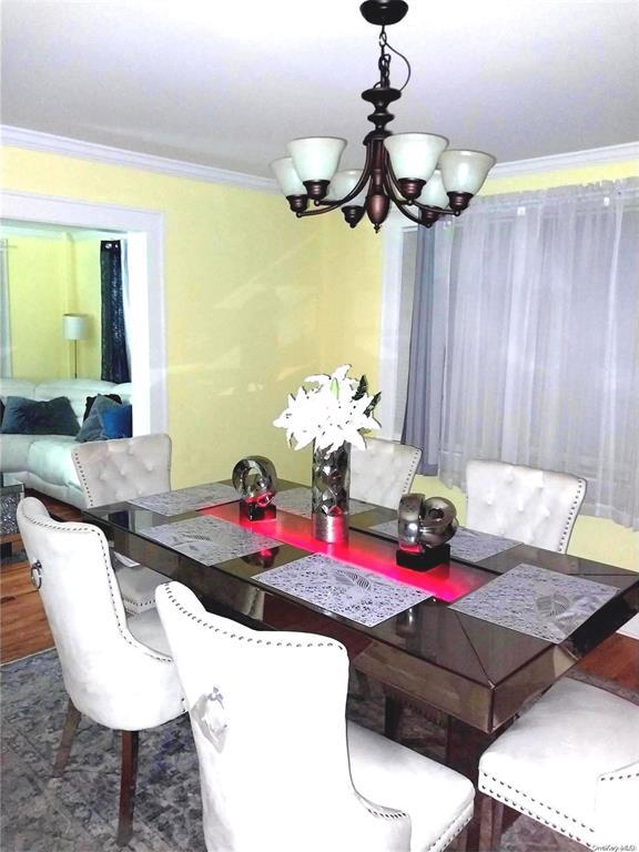 dining room with crown molding and an inviting chandelier