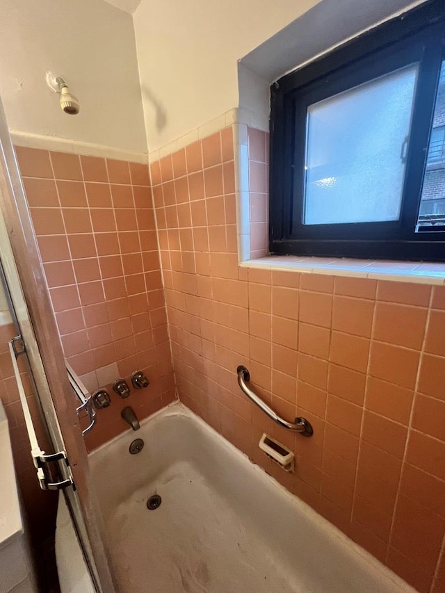 bathroom featuring tiled shower / bath