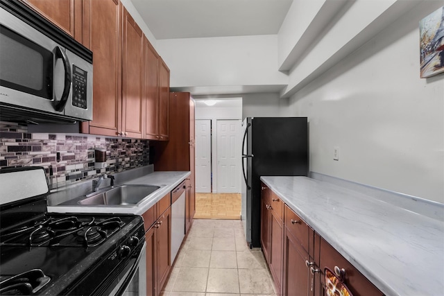 kitchen featuring backsplash, sink, light tile patterned floors, and black appliances